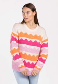 Wielokolorowy sweter dziany z zygzakowymi wzorami w odcieniach różu, pomarańczu i kremu. Okrągły dekolt oraz długie rękawy z prążkowanymi mankietami.