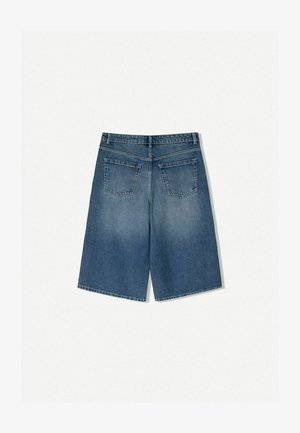 Shorts in denim di colore blu medio con una vestibilità larga. Presenta due tasche posteriori e un orlo pulito. Realizzati in un tessuto denim resistente.