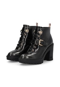Schwarze Lackleder-Stiefeletten mit einem klobigen hohen Absatz, Schnürung an der Vorderseite, dekorativem Schnallen-Design und metallischen Akzentdetails. Strukturierte Sohle.
