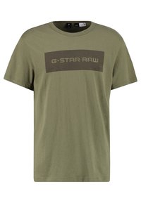 Camiseta de algodón verde oliva con mangas cortas, escote redondo y un gráfico rectangular en verde oscuro que dice "G-Star RAW" en el pecho.