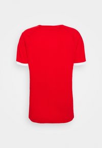 Camiseta roja de manga corta con cuello redondo, que presenta acentos blancos en las mangas. Hecha de una tela suave con una textura lisa.