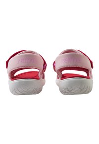 Rosa sandaler med justerbara remmar och vita gummisulor, med en böjd form och texturerat mönster för grepp. "Relima"-logotyp på remmarna.