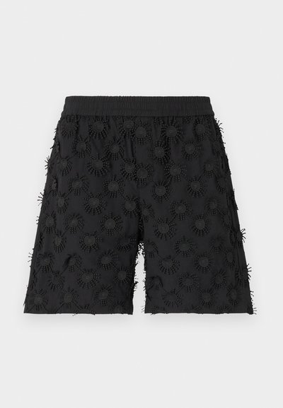 Schwarze Shorts mit einem elastischen Bund, verziert mit strukturierten, kreisförmigen Mustern und Stickereien, die einen dreidimensionalen Effekt erzeugen.