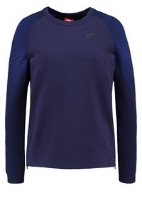 Nike sweatshirt i marinblått, med en slät kropp, texturerade ribbade detaljer på ärmarna och en liten logotyp på bröstet.