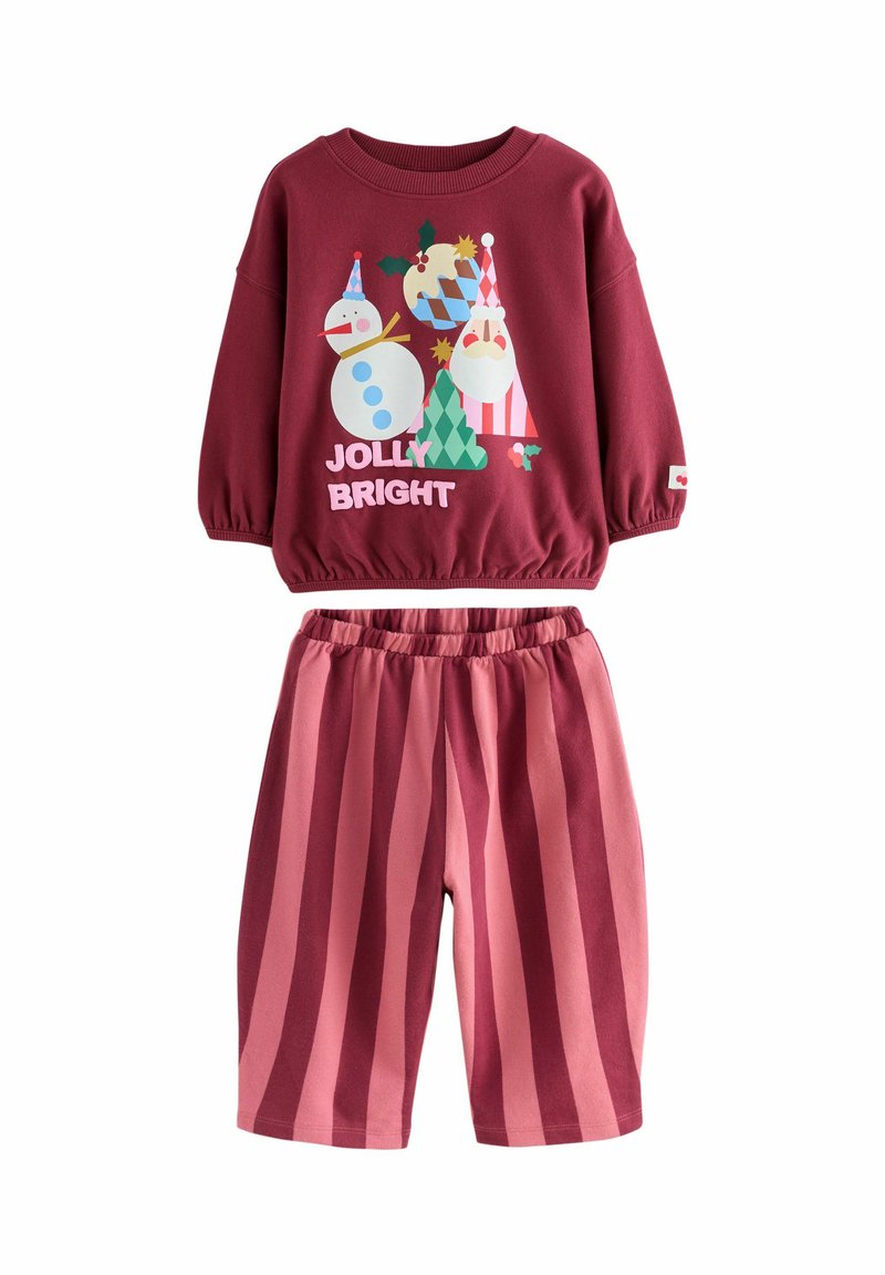 Bordový sveter s elastickými manžetami s farebnou vianočnou grafikou a nápisom "JOLLY BRIGHT." Rúžovo pruhované šortky s elastickým pásom.