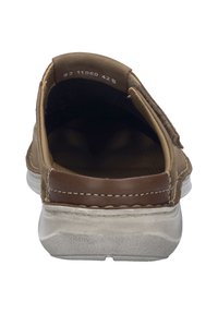 Hnědá kožená slip-on obuv s texturovaným povrchem, kontrastním hnědým detailem na patě a bílou gumovou podrážkou. Vnitřek je tmavý.