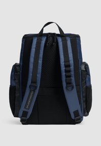 Mørkeblå rygsæk med polstrede skulderstropper, mesh rygpanel og sorte sidelommer. Har et håndtag til at bære på toppen og holdbare lynlåse.