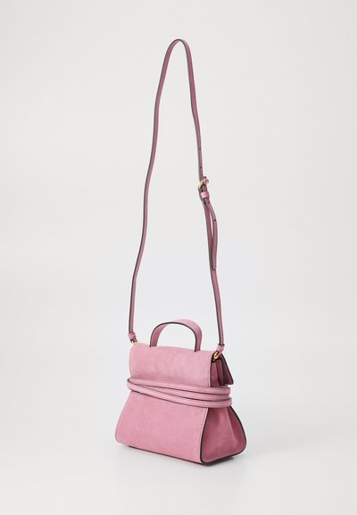 Rozā zamšādas rokas soma ar augšējo rokturi un regulējamu plecu siksnu, ar savelkumu un melniem akcentiem. Gluda tekstūra.