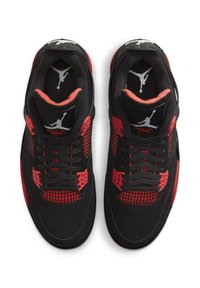 Scarpe sportive nere con accenti rossi e dettagli in rete. Presentano una tomaia in tessuto testurizzato, colletto imbottito e logo sulla linguetta.