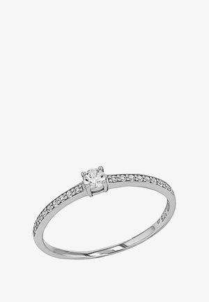 Anillo de plata con un diamante redondo central, acentuado por diamantes más pequeños a lo largo de la banda. Acabado pulido con una textura suave.