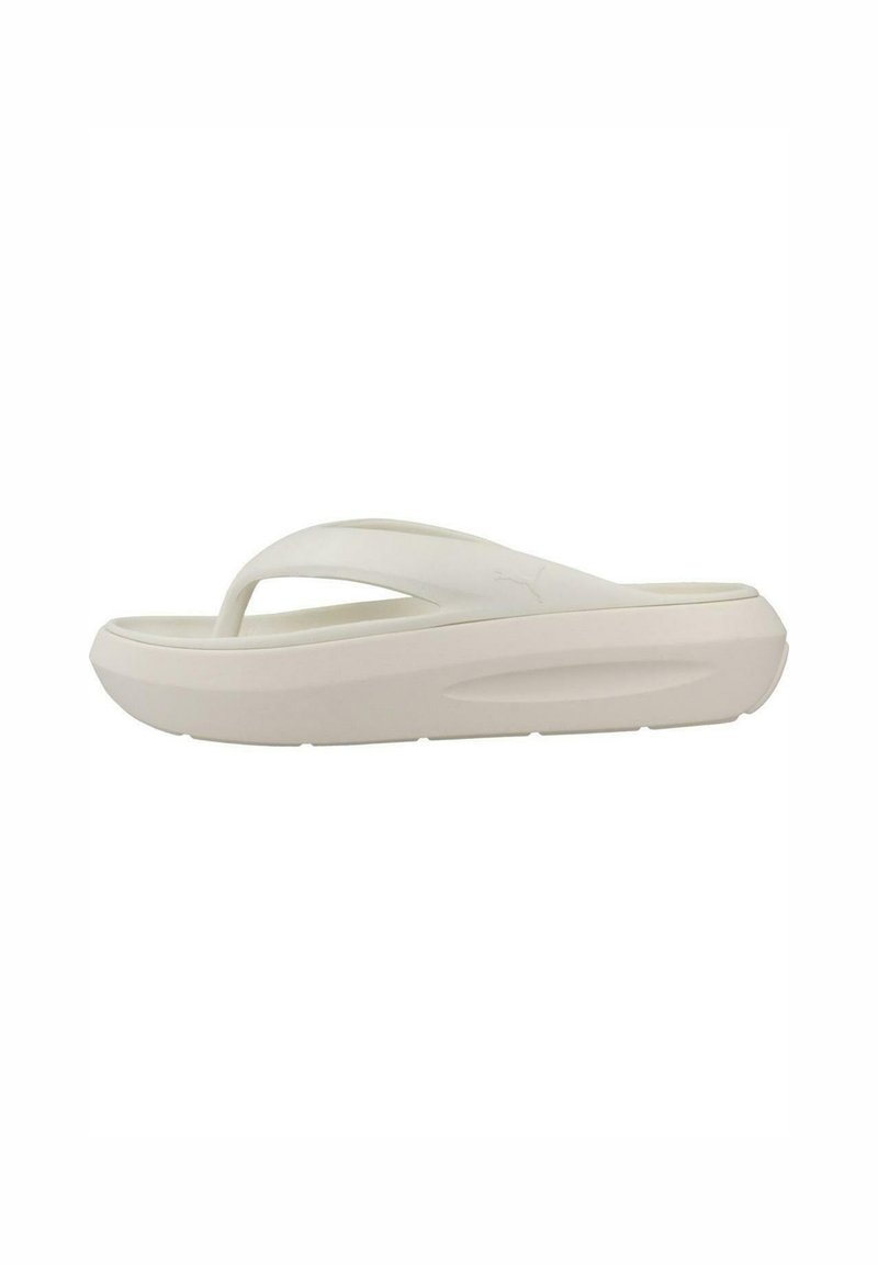 Sandalia flip-flop blanca con suela gruesa, textura suave y diseño minimalista. Presenta una correa en forma de Y para brindar soporte al pie.