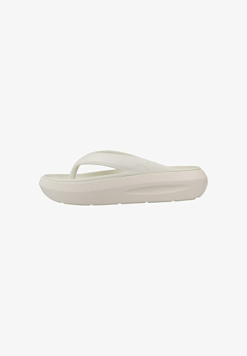 Sandalia flip-flop blanca con suela gruesa, textura suave y diseño minimalista. Presenta una correa en forma de Y para brindar soporte al pie.