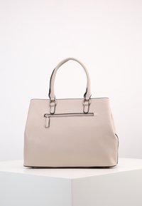 Beżowa skórzana torebka z dwoma okrągłymi uchwytami, z przednią kieszenią na zamek błyskawiczny i kontrastowymi czarnymi akcentami wzdłuż krawędzi.