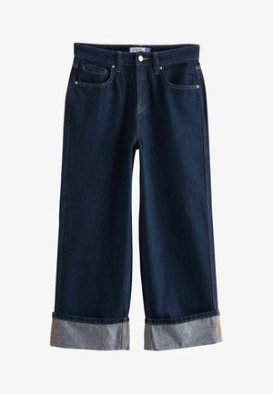 Mörk denim byxor med vida ben och uppvikta benavslut, femfickorsdesign, kontrasterande sömdetaljer och silvernit. Texturen är slät och robust.