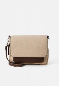 Bež zaponka torbica iz semiša z rjavim usnjenim poudarkom na dnu, s preklopno zaponko in nastavljivim naramnim trakom.