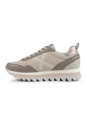Sneaker grigio chiaro in pelle liscia, con dettagli testurizzati, elementi perforati e suola bianca spessa con scanalature a zigzag.