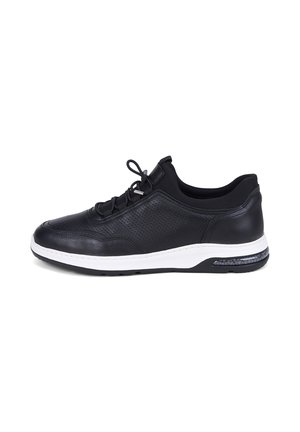 Schwarzer Ledersneaker mit perforierten Seiten, schwarzen Schnürsenkeln, weißer Sohle und luftgepolsterter Ferse, von der Außenseite gezeigt.