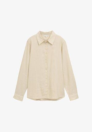 Gai bēšas krāsas garas piedurkņu krekls ar pogājamu priekšpusi, klasisku apkakli, mīkstu tekstūru un nedaudz noapaļotu apakšējo malu. Nav redzamu rakstu vai akcentu.