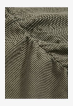 Zbliżenie na pomarszczony, oliwkowo-zielony materiał w prążki z teksturowanym, dzianinowym wzorem.