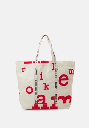 Sac fourre-tout beige avec des lettres rouges dispersées et des poignées beiges imprimé avec les textes "marimekko" et "koodi" en noir.