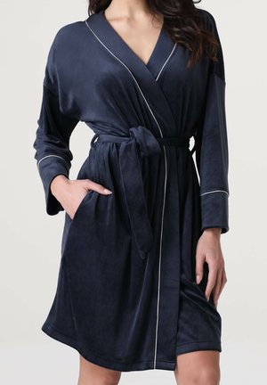 Accappatoio in peluche blu navy con colletto a scialle, piping bianco, cintura e tasche laterali. Tessuto morbido e design al ginocchio.