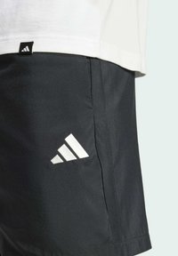 Mustat urheilushortsit, jotka on valmistettu kevyestä materiaalista. Niissä on valkoinen kolmantena viivana oleva logo ja sivusaumapocket.