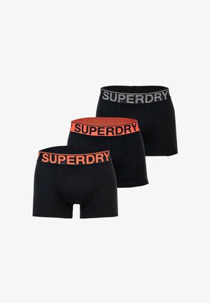 Tres pares de bóxers negros con cinturillas elásticas con marca en negro y naranja, dos con "SUPERDRY" en naranja y uno en gris.