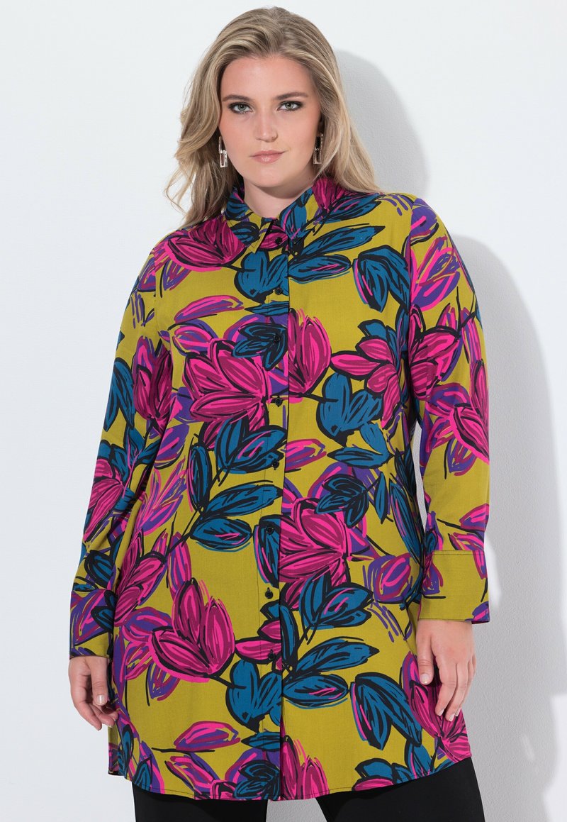 Košile s dlouhým rukávem, která má velké růžové a modré květinové vzory na hořčicovém pozadí. Vyrobena z měkkého materiálu s límečkovým designem.