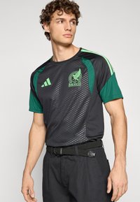 Black and green deportivo t-shirt featuring a Mexico national team logo, short sleeves, and a textured pattern on the fabric.