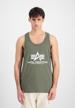 Camiseta sin mangas de algodón verde oliva con un logo blanco de diseño geométrico, escote redondo y etiqueta lateral.