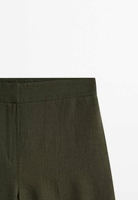 Pantalons légers vert olive, légèrement texturés, avec une taille lisse et des poches latérales, présentant un design à coupe droite.