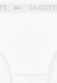 Lacoste white men's briefs with a soft, stretchy cotton material, featuring a gray branded waistband and a simple design without patterns.