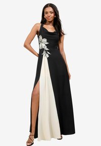 Rochie maxi neagră și crem, cu broderie florală pe bodice și o fanta laterală, având un decolteu rotunjit și bretele subțiri reglabile.