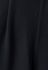 Zwarte stof met een gladde, matte textuur, met subtiele plooien en vouwen. Geen duidelijke patronen of versieringen zichtbaar.