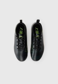 Pár čiernych futbalových kopačiek Puma s neonovo zelenými akcentmi, šnúrkami a ťahacími úchytmi, zobrazené zvrchu na bielom pozadí.