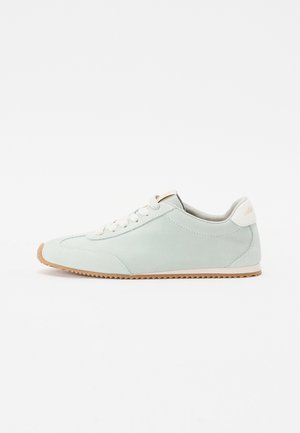 Lichtgroene suède sneaker met een afgeronde neus, witte veters en een tan rubberen zool. Bevat een subtiele logo op de hiel.