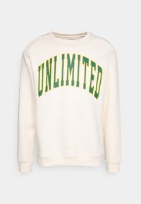 Cremiges Sweatshirt mit langen Ärmeln und rundem Ausschnitt. Mit fettem, gewölbtem "UNLIMITED"-Schriftzug in Grün und Gelb. Weicher Stoff.