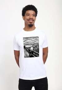 Bílý tričko s černým liniovým kreslením uměleckého díla "Výkřik". Design zahrnuje výrazné kontury a vlnité pozadí.