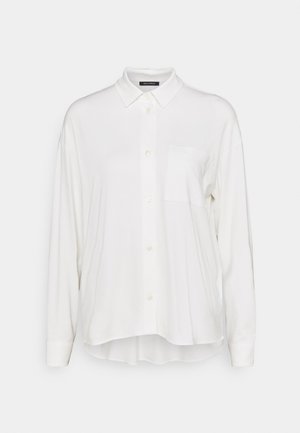 Chemise blanche à manches longues avec boutons, col et poche poitrine, coupe décontractée, ourlet arrière légèrement plus long.