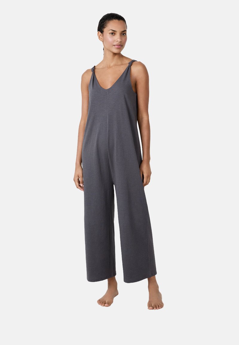 Mono gris sin mangas con escote en V, pantalones anchos y tirantes anudados, hecho de una tela suave que ofrece un ajuste relajado y un diseño sencillo.
