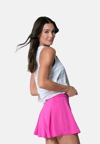 Top bianco senza maniche con righe grigie, abbinato a una gonna plissettata di un vivace color rosa. Tessuto liscio e design aderente.