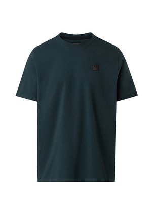 Camiseta de cuello redondo de manga corta en verde oscuro con un pequeño parche de logo cuadrado negro en el lado izquierdo del pecho.