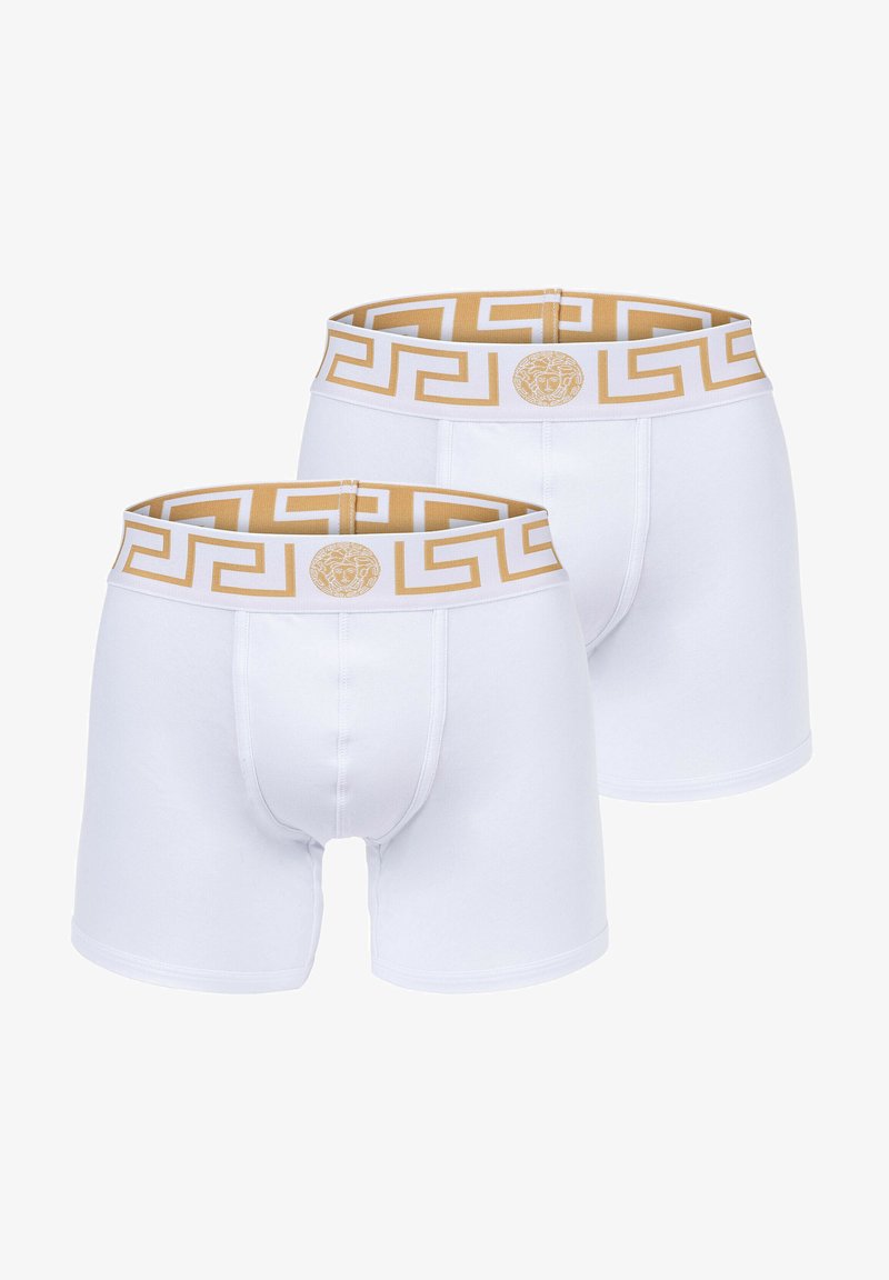 White boxer briefs with a gold pattern waistband, featuring a Greek key design and a logo accent. Made from soft, stretchy fabric.