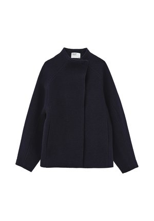Cappotto di lana blu navy con colletto alto, apertura anteriore e due tasche laterali. Presenta una silhouette strutturata e squadrata e un tessuto testurizzato.