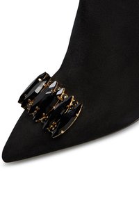 Scarpa in suede nera a punta con un accento di gioiello nero multifacettato fissato da una minuteria dorata sul lato superiore.