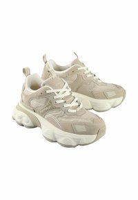 Beige Sportsneaker mit Obermaterial aus Mesh und Wildleder, dicker weißer Sohle, Schnürverschluss und Branding an den Seiten und auf der Zunge.