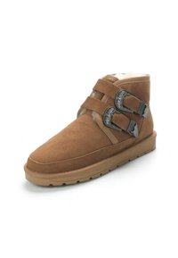 Botas de tobillo de ante marrón con dos hebillas metálicas decorativas, un suave forro interior y una suela de goma plana.