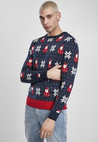 Pull en tricot bleu marine avec motifs de Père Noël et flocons de neige, avec des accents rouges aux poignets et à l'ourlet, confectionné dans un tissu doux.