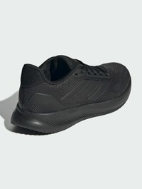 Chaussure de sport noire avec une tige texturée, un système de laçage et une semelle rembourrée avec des motifs striés pour une meilleure adhérence.