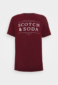 Maronfarvet bomulds t-shirt med fed hvid tekst: "AMSTERDAMS SCOTCH & SODA BLAUW" på brystet i en standard crew neck design.